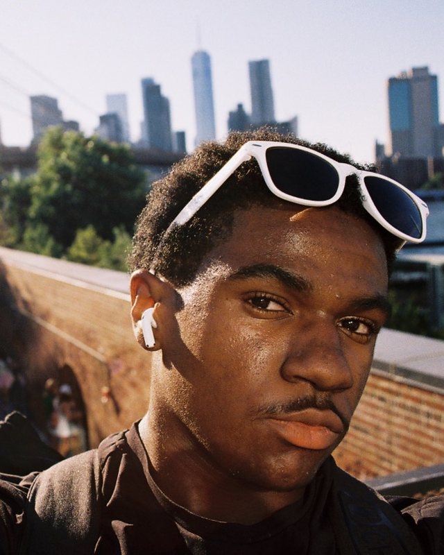 Theodore King IV in white sunglasses, with the Lower Manhattan skyline behind him